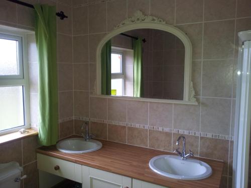 a bathroom with two sinks and a mirror at Rosswood House in Donegal