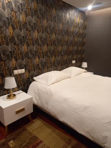 a bedroom with a white bed and a wall at Com o Douro à vista in Jovim