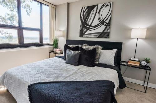 Un dormitorio con una cama grande y dos ventanas. en Modern condo closest to the University of SC, en Columbia