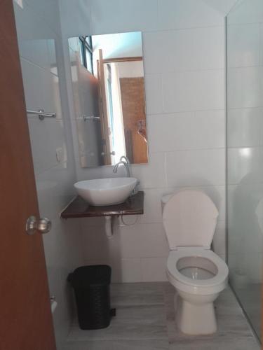 a bathroom with a white toilet and a sink at Casa Campestre con piscina privada- Anapoima in Anapoima