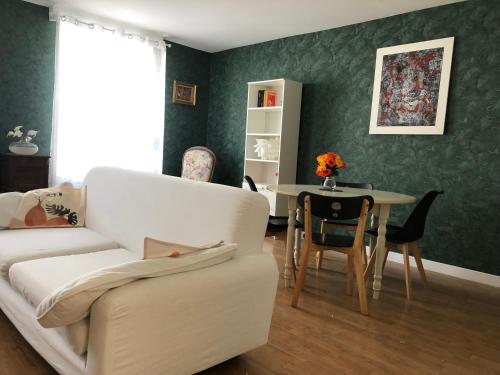 un salon avec un canapé et une table dans l'établissement Le Voyageur Sur le sable du samedi au samedi pendant les vacances scolaires, à Berck-sur-Mer