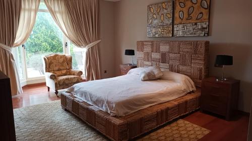 a bedroom with a bed and a chair and a window at Casa San Roque in Villanueva de Arosa