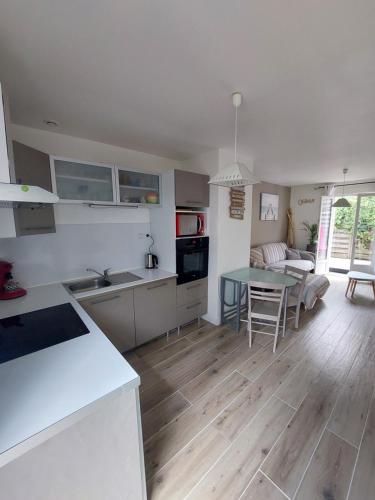 une cuisine et un salon avec une table et un canapé dans l'établissement Gite Calme à 900m de la plage et 700m Centre Ville, à Saint-Georges-de-Didonne