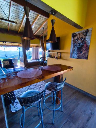 a kitchen with a large wooden counter and chairs at Horizonte azul sussuarana in Gonçalves