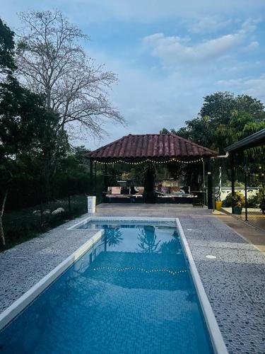 a swimming pool with a gazebo in a yard at Casa Campestre con piscina privada- Anapoima in Anapoima