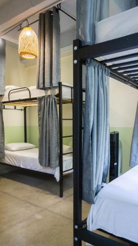 a room with three bunk beds and a lamp at Selva House in Medellín