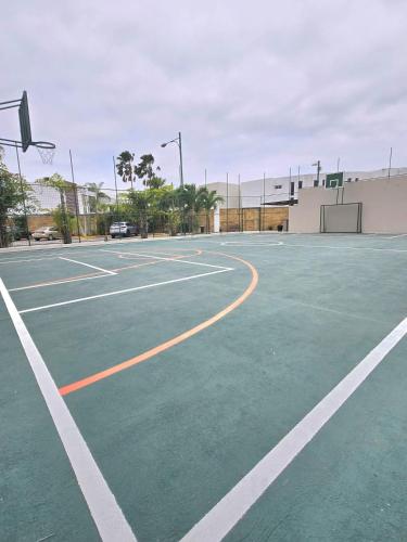 an empty tennis court with a basketball hoop at Moderno, brillante y parqueo in SamborondÃ³n