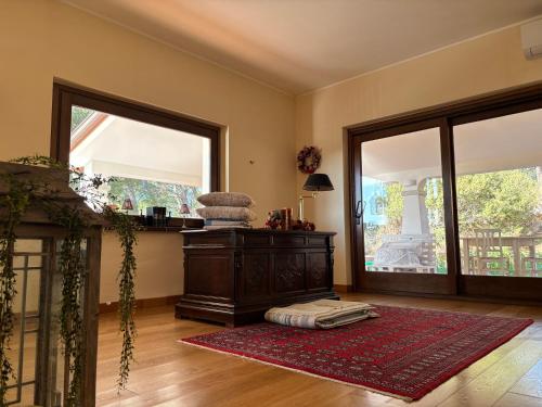 a living room with two large windows and a red rug at Grandma Lella in Carbonia
