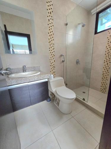 a bathroom with a toilet and a sink and a shower at Moderno, brillante y parqueo in SamborondÃ³n