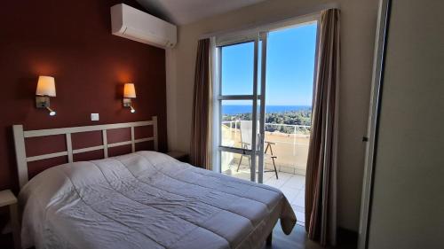 une chambre avec un lit et une grande fenêtre dans l'établissement Résidence le Village de Cap Esterel - maeva Home - Appartement 2 pièces 6 personnes - Prestige MAE-4121, à Saint-Raphaël