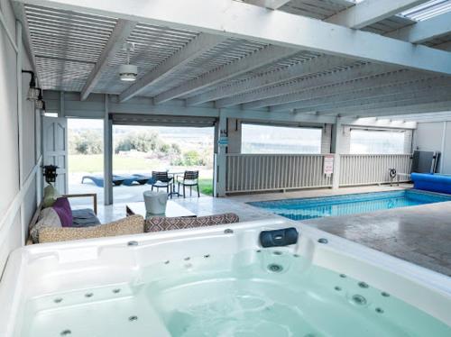 a large bath tub in a room with a swimming pool at Gold 68- גולד 68 סוויטות בוטיק in Kefar Barukh