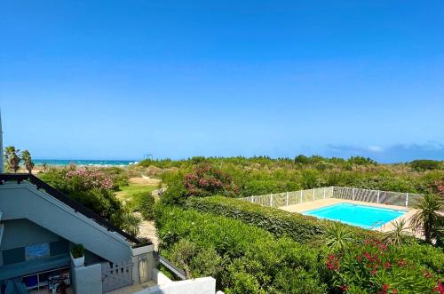 - une vue sur la piscine et l'océan dans l'établissement Appartement entre la lagune et la mer avec piscine, direct plage, vue partielle mer, à Saint-Cyprien