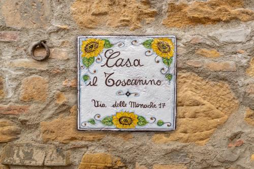 a sign on the side of a stone wall at Casa il Toscanino in Gambassi Terme
