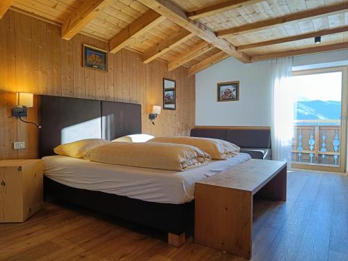a bedroom with a large bed with a wooden ceiling at Chalet Frapes in San Martino in Badia