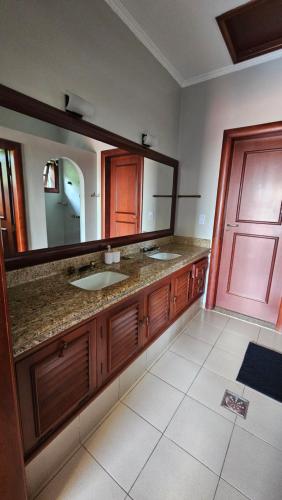 a bathroom with two sinks and a large mirror at Casa Saito in Campinas