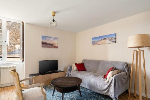 un salon avec un canapé et une télévision dans l'établissement Le Corsaire de Solidor Studio, à Saint-Malo