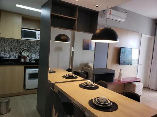 Bahia Astron Mundial Hotel Flats في سلفادور: مطبخ وغرفة معيشة مع طاولة وكراسي