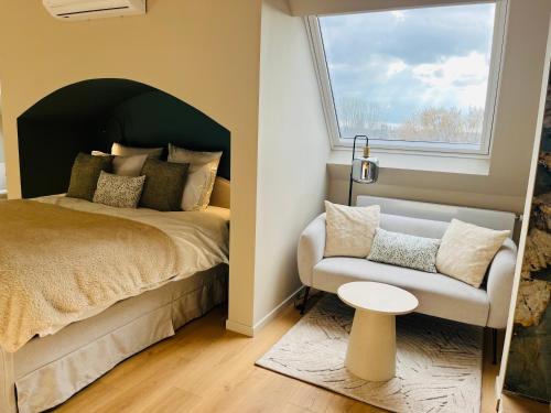 a bedroom with a bed and a chair and a window at Chambre d'hôtes Stellina Bed&Breakfast avec vue sur jardin arboré in Tournai
