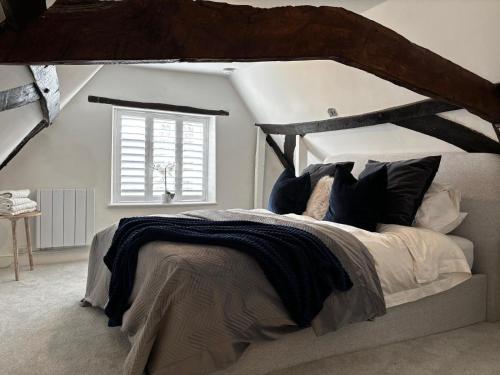 a bedroom with a large bed with a wooden headboard at Cromwell Cottage - Dog Friendly in Fakenham