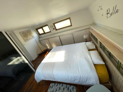 - une chambre avec un grand lit blanc et 2 fenêtres dans l'établissement Nuit insolite à bord d'une péniche, 6 personnes, à Bergues