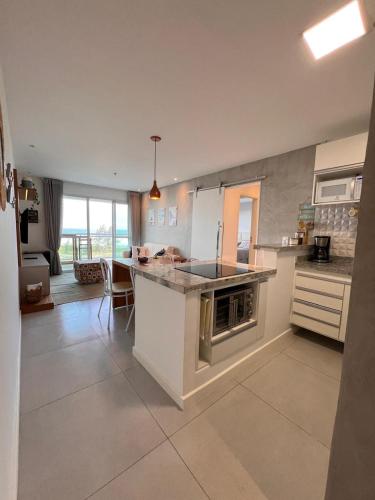 a large kitchen with a counter and a kitchen island at Mandai Apartamentos in Cabo Frio