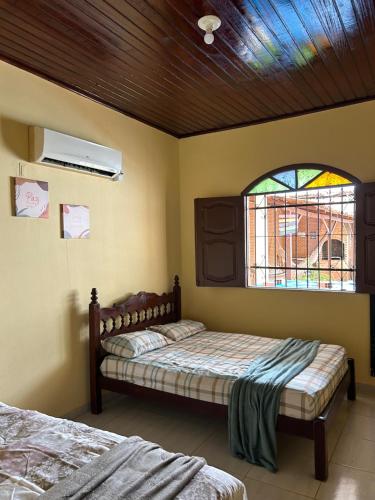 a bedroom with two beds and a stained glass window at Paraíso no Chapéu Virado in Belém