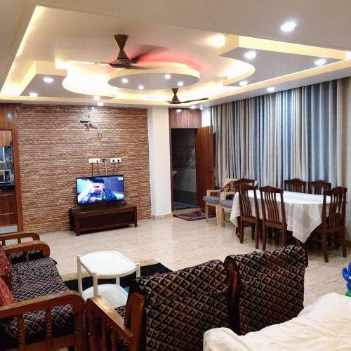 a living room with a tv and a table and chairs at RP Green Complex 1BHK Apartment in Rāe Bareli