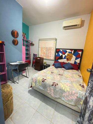 a bedroom with a bed with a colorful comforter at Casa en el centro de veracruz in Veracruz