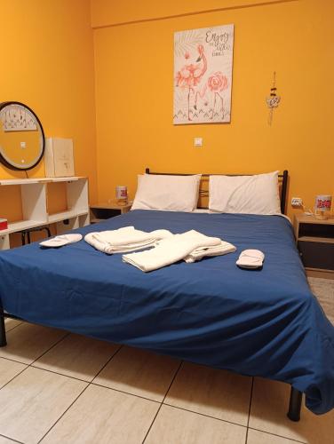 a bed with blue sheets and towels on it at Πλάτανος Στούντιο ΙΙΙ PLATANOS STUDIO III in Mytilene
