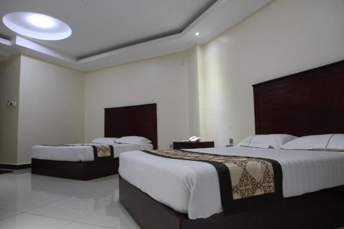 Un pat sau paturi într-o cameră la Namayiba Park Hotel Kampala