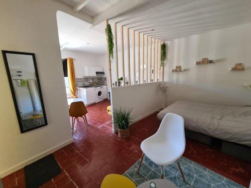 - une chambre avec un lit et une chaise blanche dans l'établissement Cosy downtown studio, à Apt