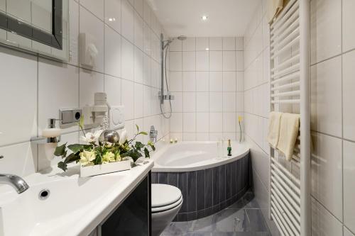 La salle de bains est pourvue d'une baignoire, de toilettes et d'un lavabo. dans l'établissement Hotel am Brenner, à Tauberbischofsheim