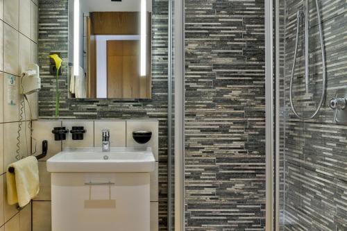 a bathroom with a sink and a shower at Hotel am Brenner in Tauberbischofsheim