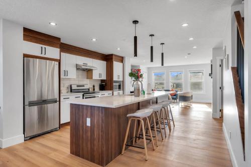 a kitchen with a large island with bar stools at Your Pleasant stay in 3 bedroom House in Saddle-Ridge in Calgary