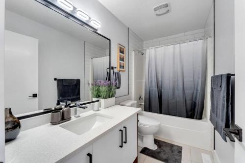 biała łazienka z umywalką i toaletą w obiekcie Your Pleasant stay in 3 bedroom House in Saddle-Ridge w mieście Calgary