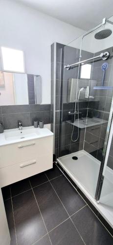 une salle de bain avec douche et lavabo dans l'établissement L'Échappée Bleue, cosy design 2mn mer, au coeur du centre ville, à La Grande Motte