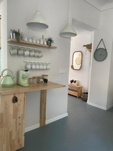 a kitchen with a wooden counter and shelves at Casa EA in Cazorla