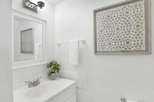 a white bathroom with a sink and a mirror at Private Beach-Private Pool-Easy walk to the Beach in Gulf Highlands