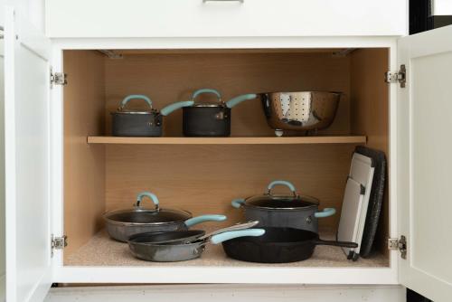 a cupboard with pots and pans in it at Private Beach-Private Pool-Easy walk to the Beach in Gulf Highlands