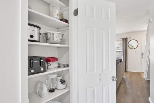 a white pantry with white shelves and a door at Private Beach-Private Pool-Easy walk to the Beach in Gulf Highlands