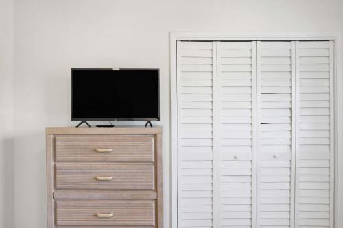 a tv sitting on a dresser next to a closet at Private Beach-Private Pool-Easy walk to the Beach in Gulf Highlands