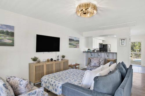 a bedroom with a bed and a couch and a tv at Private Beach-Private Pool-Easy walk to the Beach in Gulf Highlands