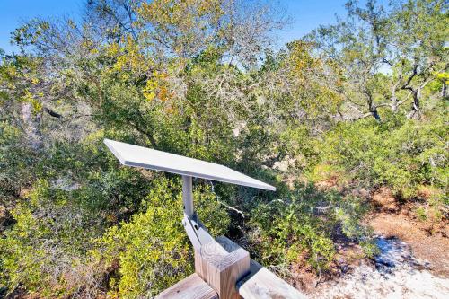 a bench with a white umbrella in front of trees at Private Beach-Private Pool-Easy walk to the Beach in Gulf Highlands