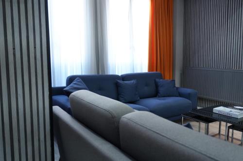 a living room with a blue couch and a table at Casa Florya Travel Apartments in Istanbul
