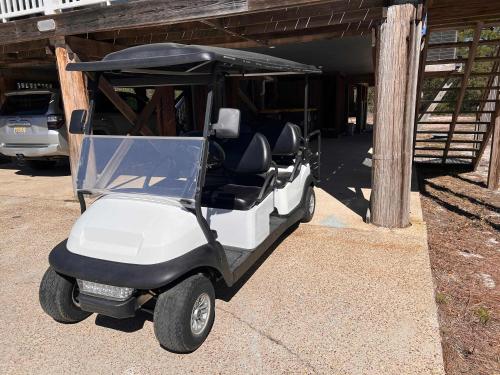 a golf cart parked next to a building at Private Beach-Private Pool-Easy walk to the Beach in Gulf Highlands