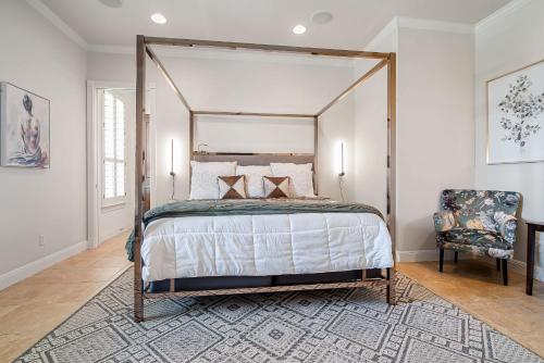 une chambre avec un lit à baldaquin et une chaise dans l'établissement King Beds Hot Tub On 290 Large Estate Kitchen, à Fredericksburg