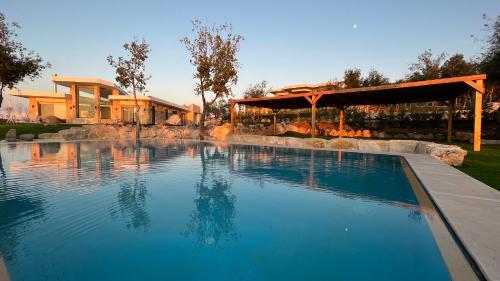 a swimming pool in a backyard with a pavilion at Villa Galli & Leo in Jbeil