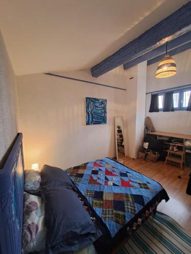 une chambre avec un lit avec une couette dessus dans l'établissement Pretty little fisherman's house, à Sète