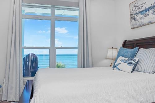 Un dormitorio con una cama y una ventana grande. en Just Beachy by Pristine Properties Vacation Rentals, en Mexico Beach