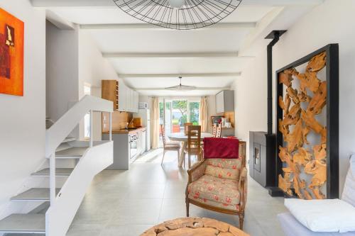 Il comprend un salon et une cuisine avec un escalier et une chaise. dans l'établissement Maison, 150 m de la plage, la Tresson,Noirmoutier, à La Guérinière